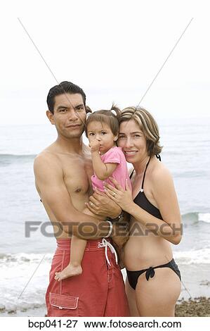Stock Photo - Parents and toddler at the beach. Fotosearch