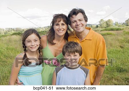 Stock Image - Portrait of happy family in field. Fotosearch