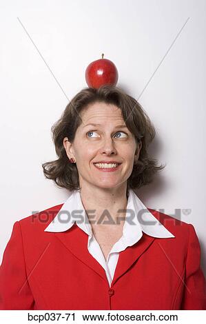Apple sitting on businesswoman's head View Large Photo Image Stock Image - Apple sitting on businesswoman's head. Fotosearch