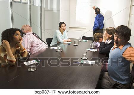 Bored and tired co-workers in meeting View Large Photo Image Stock Photo - Bored and tired co-workers in meeting. Fotosearch