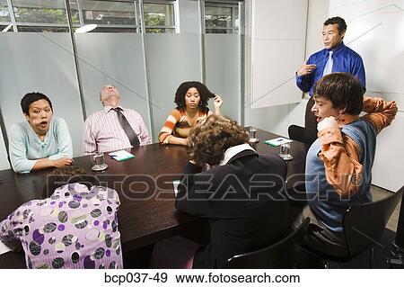 Stock Photo - Bored and tired co-workers in meeting. Fotosearch