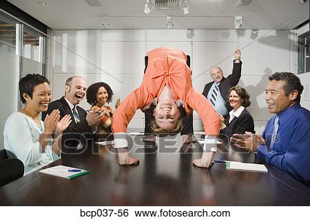 Stock Photograph - Businesswoman doing backbend at meeting. Fotosearch