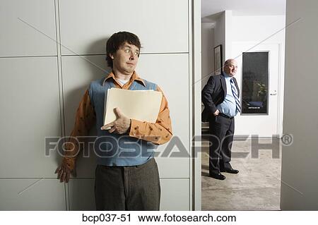 Employee hiding from the boss View Large Photo Image Stock Image - Employee hiding from the boss. Fotosearch