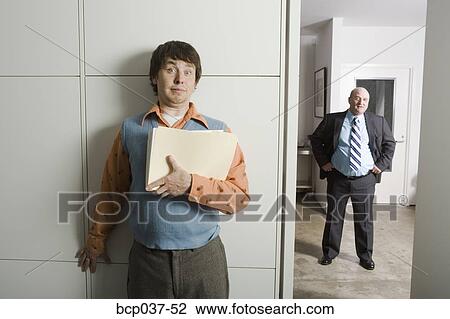 Stock Image - Employee hiding from the boss. Fotosearch
