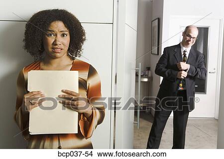 Picture - Geeky man pursuing female co-worker. Fotosearch