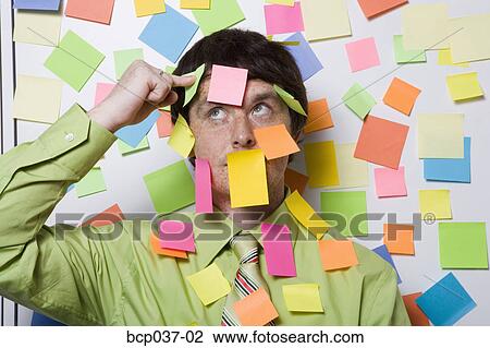 Stock Image - Male office worker covered with sticky notes. Fotosearch