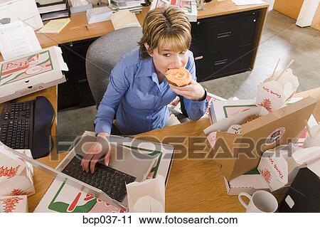 Office worker eating at desk View Large Photo Image Stock Image - Office worker eating at desk. Fotosearch