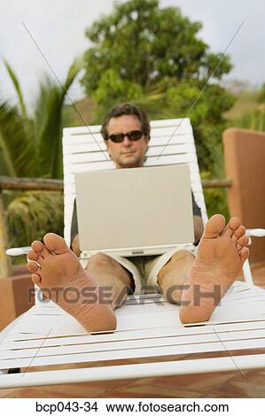 Barefoot man using laptop outside View Large Photo Image Picture - Barefoot man using laptop outside. Fotosearch