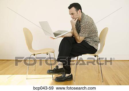 Contemplative man using laptop View Large Photo Image Stock Photo - Contemplative man using laptop. Fotosearch