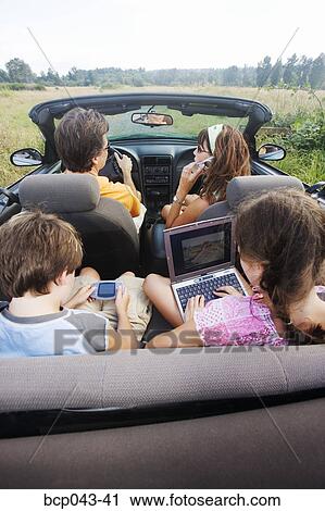 Family in convertible using portable electronics View Large Photo Image Stock Image - Family in convertible using portable electronics. Fotosearch