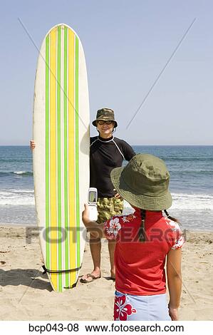 Girl snapping surfer with camera phone View Large Photo Image Stock Photo - Girl snapping surfer with camera phone. Fotosearch