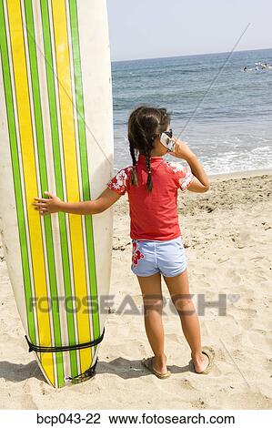 Little girl with surfboard and mobile phone View Large Photo Image Stock Image - Little girl with surfboard and mobile phone. Fotosearch