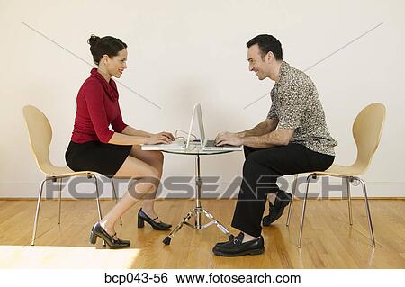 Stock Photograph - Man and woman working with laptops. Fotosearch