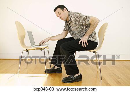 Man using laptop in bare room View Large Photo Image Stock Image - Man using laptop in bare room. Fotosearch