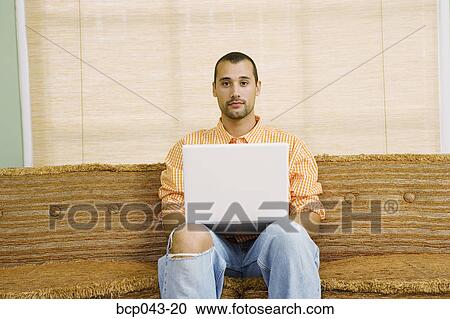 Stock Image - Man with blank stare and laptop. Fotosearch
