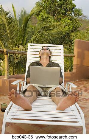 Sunbathing man with laptop outside View Large Photo Image Stock Photography - Sunbathing man with laptop outside. Fotosearch