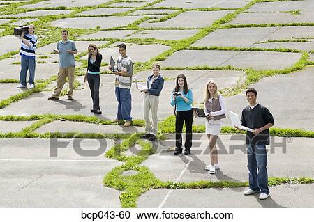 Teenagers holding electronic gadgets View Large Photo Image Stock Image - Teenagers holding electronic gadgets. Fotosearch