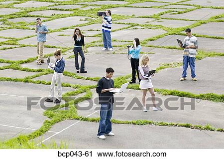 Stock Image - Teenagers using electronic gadgets. Fotosearch