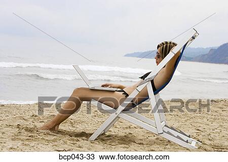 Woman using laptop at beach View Large Photo Image Stock Image - Woman using laptop at beach. Fotosearch