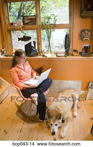 Woman using laptop at home View Large Photo Image Picture - Woman using laptop at home. Fotosearch