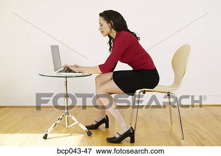 Woman using laptop in bare room View Large Photo Image Stock Photo - Woman using laptop in bare room. Fotosearch