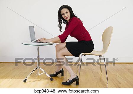 Woman using laptop in bare room View Large Photo Image Stock Photo - Woman using laptop in bare room. Fotosearch