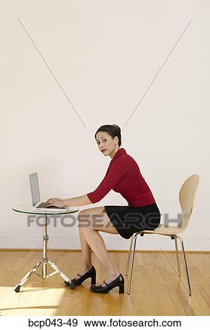 Woman using laptop in bare room View Large Photo Image Stock Photo - Woman using laptop in bare room. Fotosearch