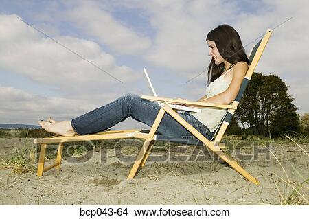 Young woman with laptop on beach View Large Photo Image Picture - Young woman with laptop on beach. Fotosearch