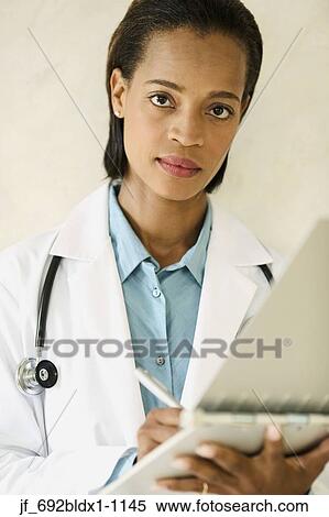 Female doctor writing on a clipboard View Large Photo Image Stock Photography - Female doctor writing on a clipboard. Fotosearch