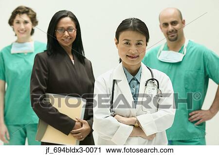 Stock Image - Group of doctors looking at camera smiling. Fotosearch