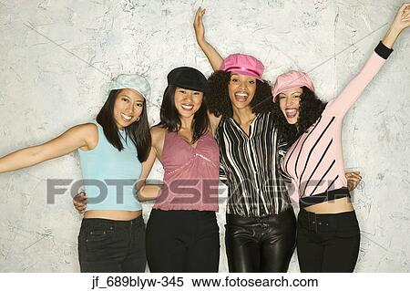 Stock Photography - Group of young women standing together looking at camera smiling. Fotosearch