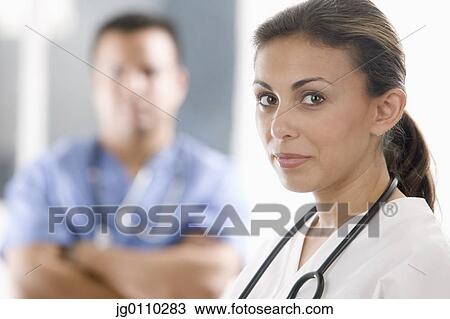 Stock Image - Portrait of a female and a male medical personnel looking at camera. Fotosearch