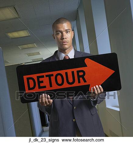 Stock Photograph - Portrait of a young man holding a signboard. Fotosearch