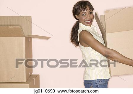 Woman carrying a cardboard box View Large Photo Image Stock Image - Woman carrying a cardboard box. Fotosearch