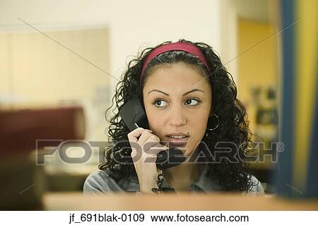 Stock Photo - Young woman talking on a phone. Fotosearch