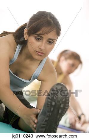 Stock Image - Young women exercising in a gymnasium. Fotosearch