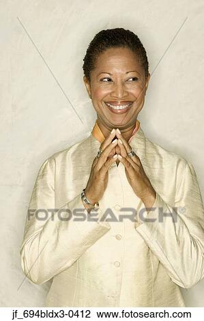 Businesswoman standing with hands together smiling View Large Photo Image Stock Image - Businesswoman standing with hands together smiling. Fotosearch