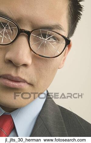 Picture - Close-up of a young businessman wearing cracked eyeglasses. Fotosearch