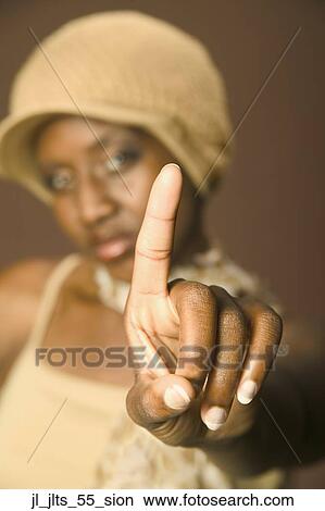Picture - Close-up of a young woman holding up her finger. Fotosearch