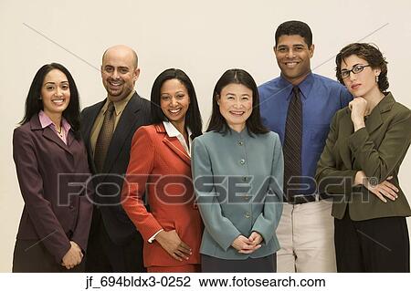 Stock Image - Group of business executives standing together looking at camera smiling. Fotosearch