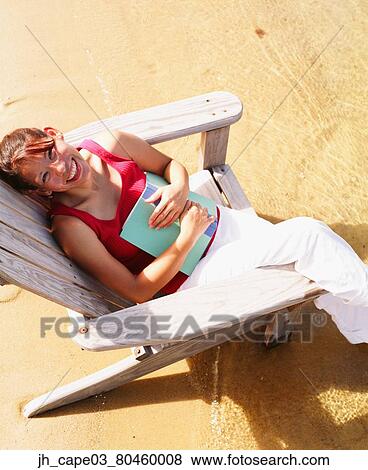 High angle view of a young woman sitting on a beach chair View Large Photo Image Stock Photo - High angle view of a young woman sitting on a beach chair. Fotosearch