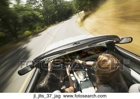 High angle view of two young women driving in a convertible car View Large Photo Image Stock Image - High angle view of two young women driving in a convertible car. Fotosearch