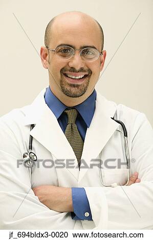 Stock Image - Male doctor looking at camera smiling. Fotosearch