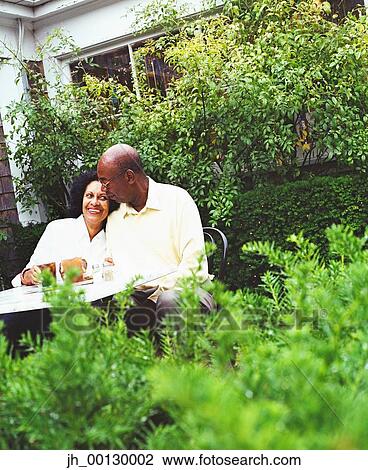 Mature couple sitting in a garden View Large Photo Image Stock Image - Mature couple sitting in a garden. Fotosearch