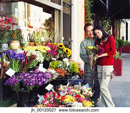 Mid adult couple standing at a flower shop View Large Photo Image Stock Photo - Mid adult couple standing at a flower shop. Fotosearch