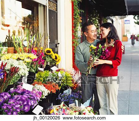 Mid adult couple standing at a flower shop View Large Photo Image Stock Photograph - Mid adult couple standing at a flower shop. Fotosearch