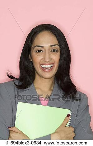 Portrait of a businesswoman holding a file smiling View Large Photo Image Picture - Portrait of a businesswoman holding a file smiling. Fotosearch