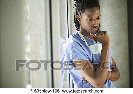 Portrait of a male medical personnel standing wearing scrubs View Large Photo Image Stock Photograph - Portrait of a male medical personnel standing wearing scrubs. Fotosearch