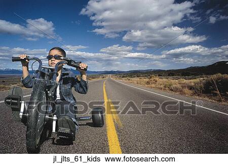 Portrait of a young boy riding a toy motorcycle on a highway View Large Photo Image Stock Photograph - Portrait of a young boy riding a toy motorcycle on a highway. Fotosearch