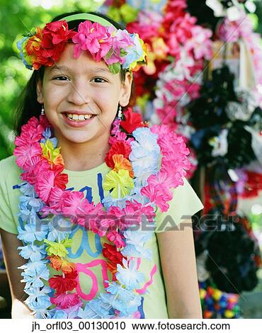 Stock Image - Portrait of a young child wearing garlands of flowers. Fotosearch